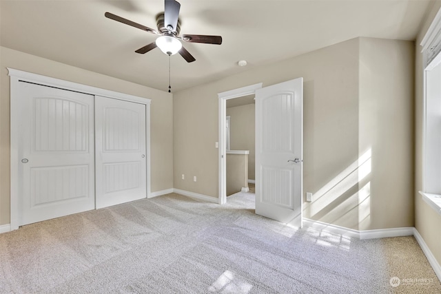 unfurnished bedroom with a closet, ceiling fan, and light colored carpet