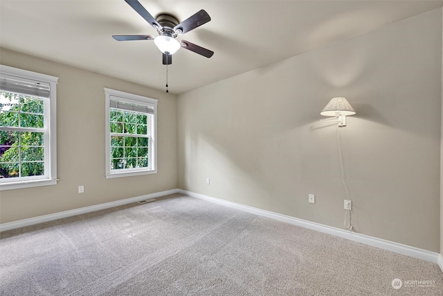 carpeted spare room featuring ceiling fan