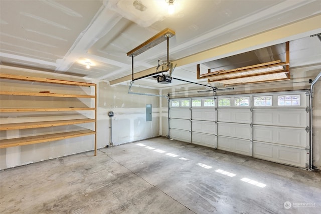 garage with a garage door opener and electric panel