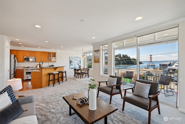 carpeted living room featuring a water view