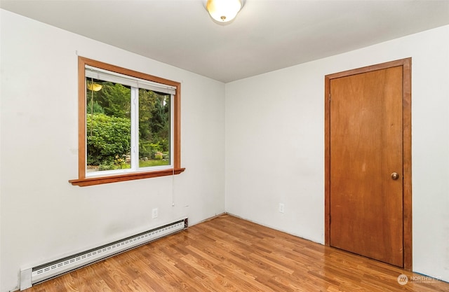 spare room with light wood-type flooring and baseboard heating