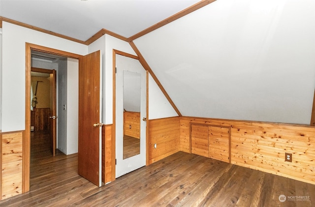 additional living space with wooden walls, vaulted ceiling, and dark hardwood / wood-style flooring