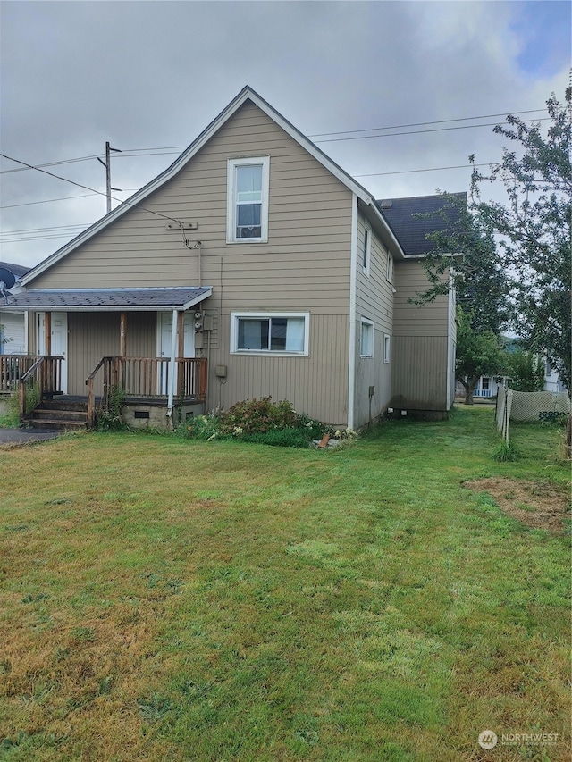 rear view of property with a lawn