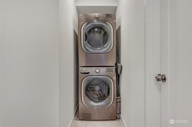 clothes washing area with stacked washing maching and dryer and light tile patterned floors