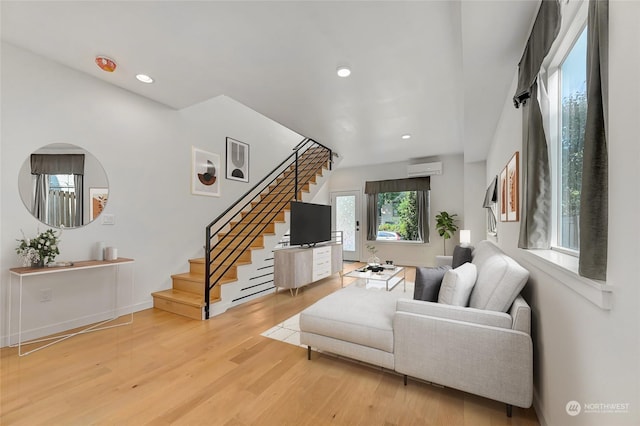 living room with wood-type flooring and a wall unit AC