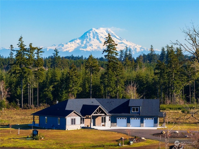 view of front facade with a garage, a mountain view, and a front lawn