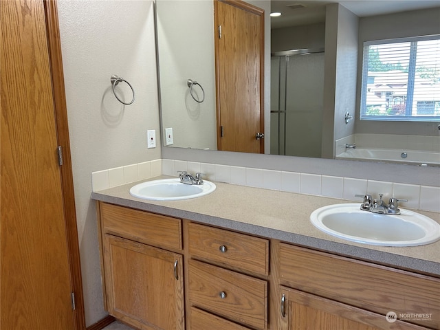 bathroom with vanity and independent shower and bath