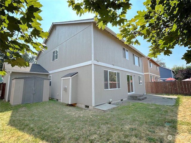 back of property featuring a storage shed and a yard