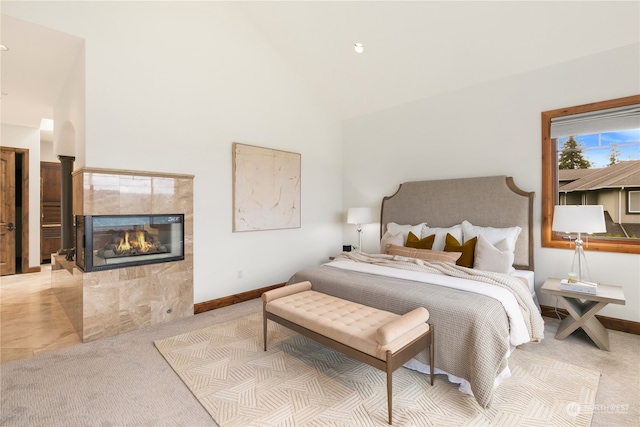 bedroom featuring a fireplace and light carpet