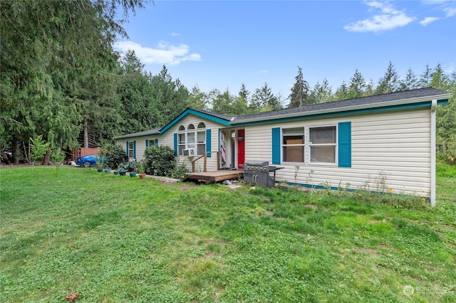 ranch-style home with a wooden deck and a front yard