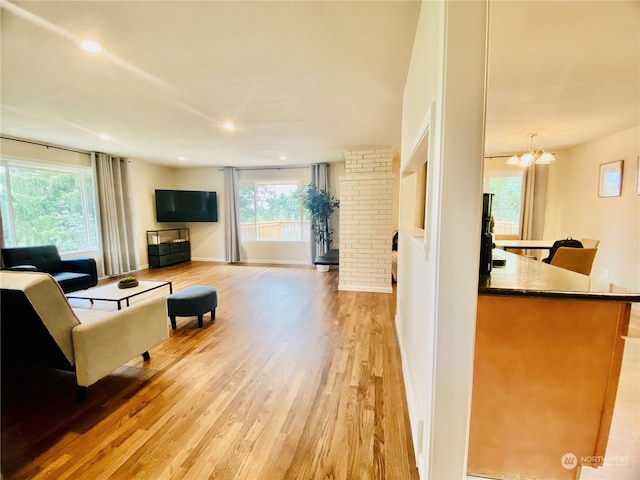 living room with light wood-type flooring and a notable chandelier