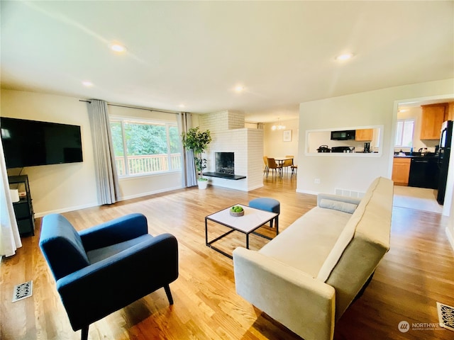 living room with light hardwood / wood-style floors and a fireplace