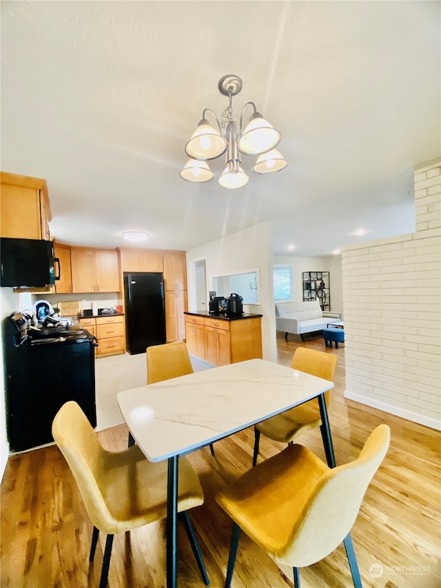 dining space with a chandelier and light hardwood / wood-style flooring