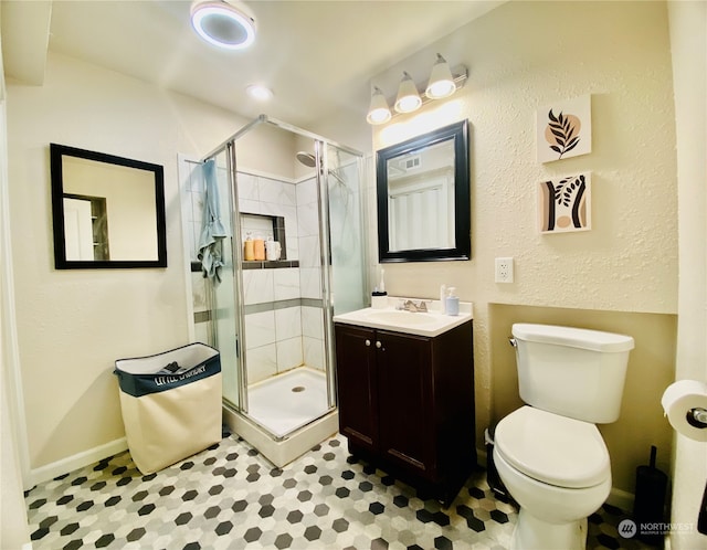 bathroom with vanity, a shower with shower door, and toilet