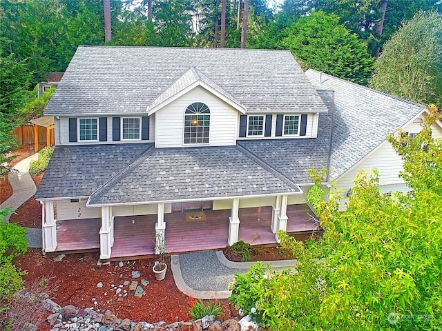 view of front of home with a shingled roof and fence