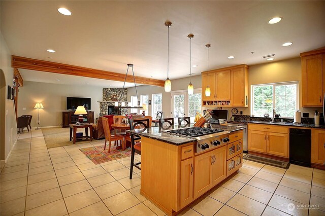 kitchen featuring stainless steel gas stovetop, a fireplace, a center island, pendant lighting, and a breakfast bar