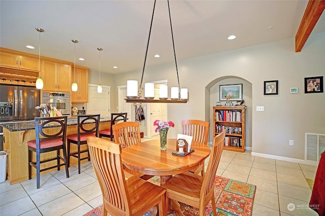 dining space with visible vents, baseboards, light tile patterned floors, recessed lighting, and arched walkways