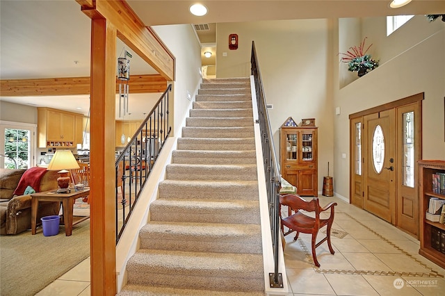 entryway featuring light tile patterned floors, visible vents, and stairway