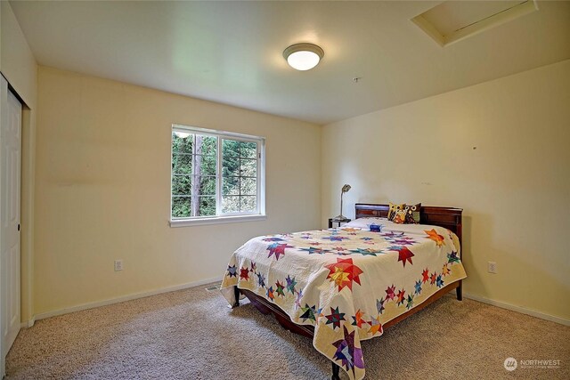 carpeted bedroom with attic access, visible vents, baseboards, and a closet