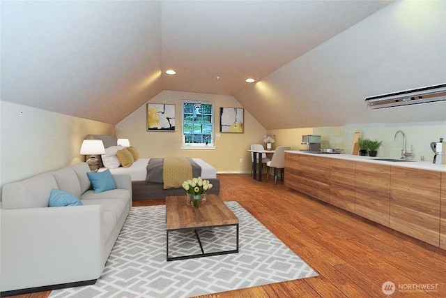 living area featuring vaulted ceiling and light wood finished floors