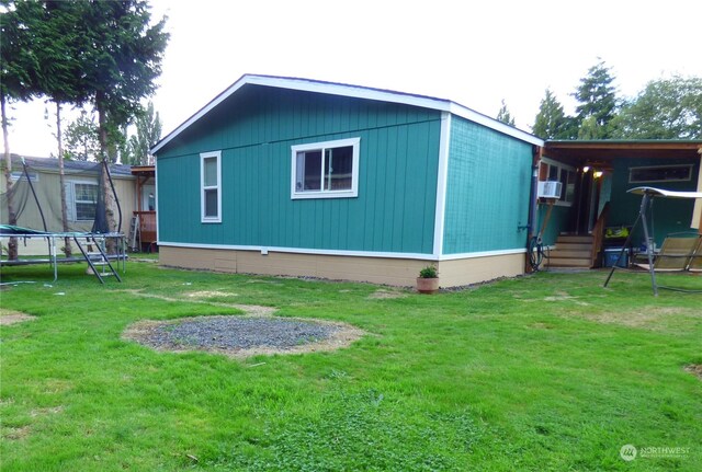 view of outdoor structure featuring a lawn and a trampoline