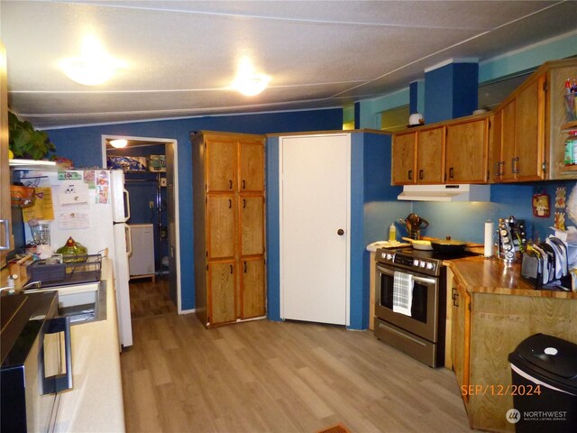 kitchen featuring white refrigerator, light hardwood / wood-style floors, and stainless steel stove