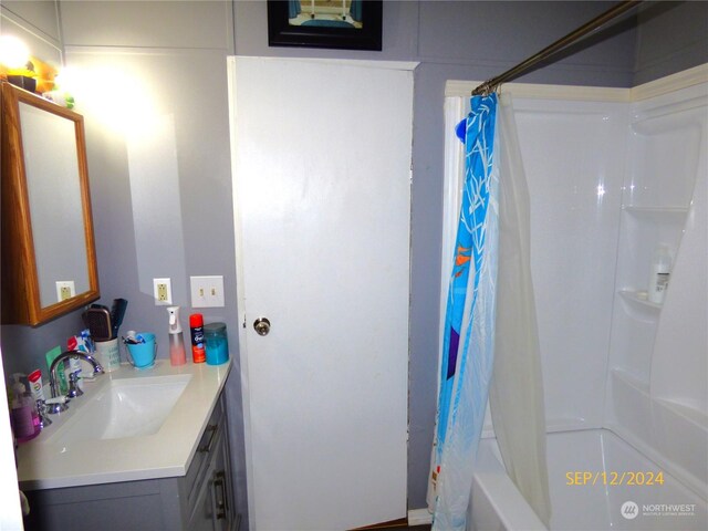 bathroom featuring shower / bath combo with shower curtain and vanity