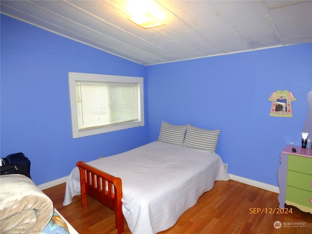 bedroom featuring lofted ceiling and hardwood / wood-style floors