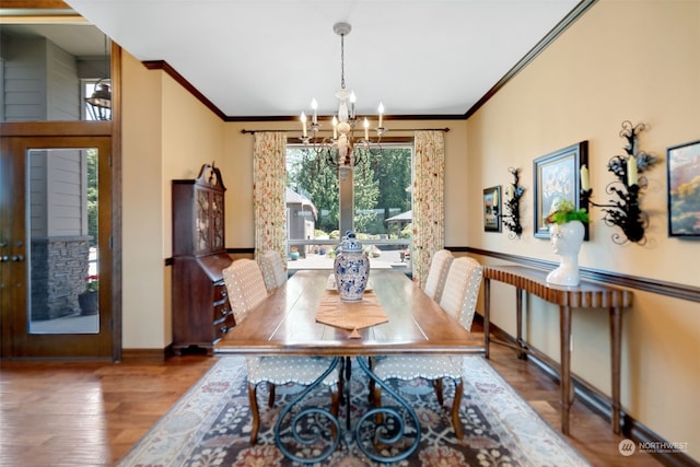 dining room with ornamental molding, hardwood / wood-style floors, and a chandelier