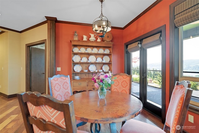 dining room featuring french doors, a chandelier, dark wood-type flooring, and crown molding