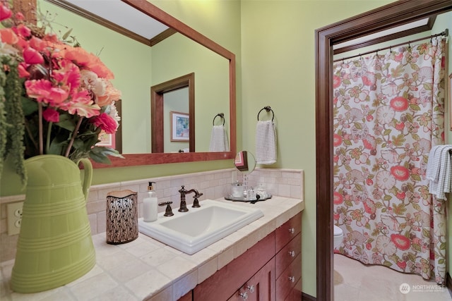 bathroom featuring vanity, toilet, and decorative backsplash