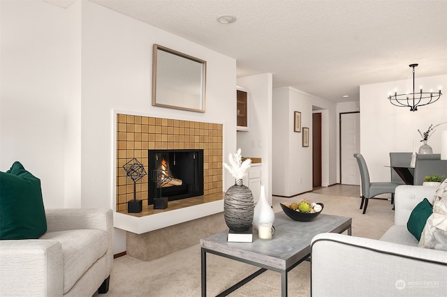 living room featuring a textured ceiling, light colored carpet, a notable chandelier, and a fireplace