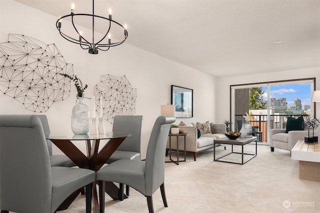 dining space with a textured ceiling, an inviting chandelier, and light colored carpet