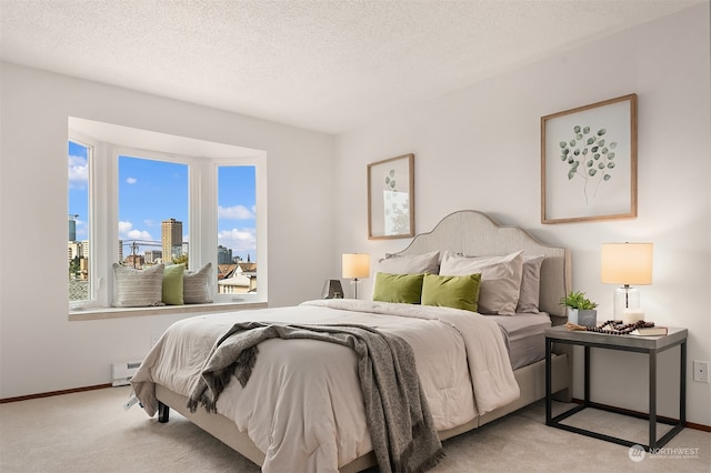 bedroom with a textured ceiling, a baseboard radiator, and light carpet