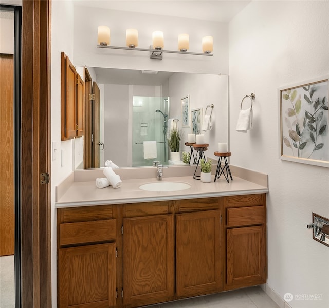 bathroom with tile patterned flooring, vanity, and a shower