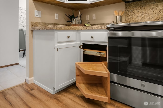 kitchen with light hardwood / wood-style flooring, white cabinets, and tasteful backsplash