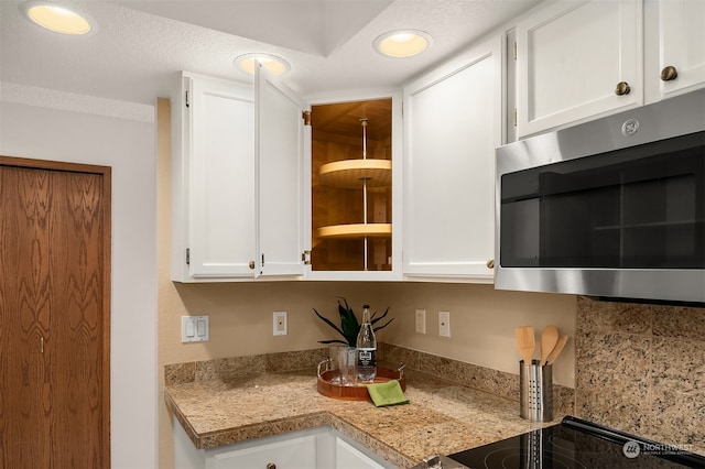 kitchen with white cabinetry and a textured ceiling