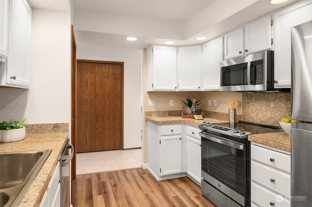 kitchen featuring light hardwood / wood-style flooring, stainless steel appliances, and white cabinetry