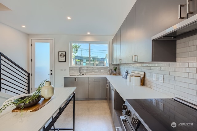 kitchen featuring gray cabinetry, appliances with stainless steel finishes, tasteful backsplash, and sink