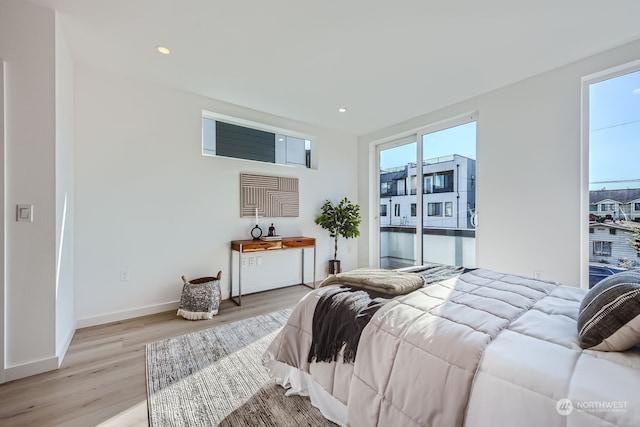 bedroom featuring access to outside, light hardwood / wood-style flooring, and multiple windows