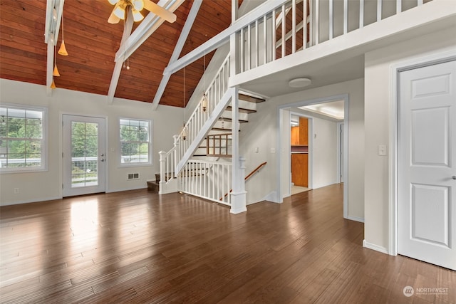 unfurnished living room with high vaulted ceiling, beamed ceiling, wooden ceiling, ceiling fan, and dark hardwood / wood-style floors