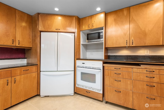 kitchen featuring light tile patterned flooring and white appliances