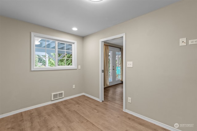 empty room featuring light wood-type flooring and french doors