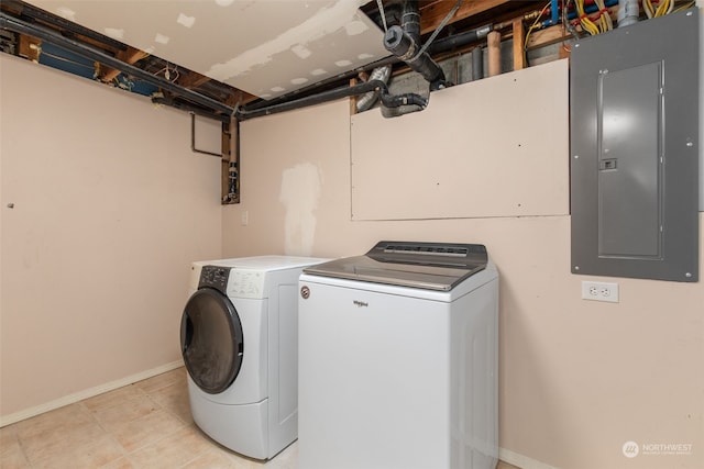 clothes washing area featuring washer and clothes dryer, electric panel, and light tile patterned floors