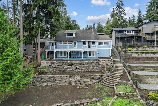 rear view of property featuring a pool side deck and a patio area