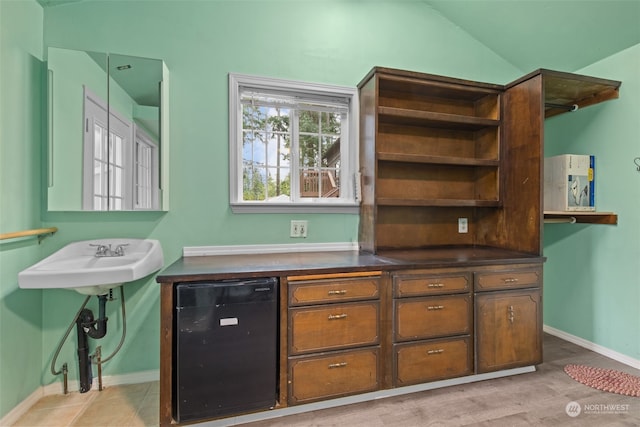 bar featuring vaulted ceiling, black fridge, and wine cooler