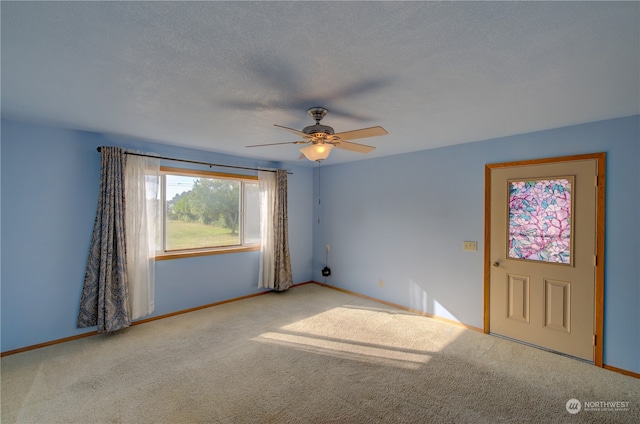 interior space with ceiling fan, light carpet, and a textured ceiling