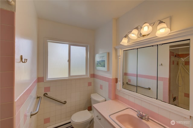 bathroom with vanity, a tile shower, tile walls, toilet, and a baseboard heating unit