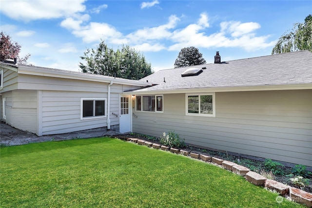 rear view of property with a lawn