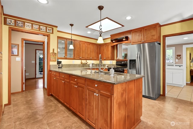 kitchen with an island with sink, stainless steel fridge, decorative light fixtures, black / electric stove, and light stone countertops